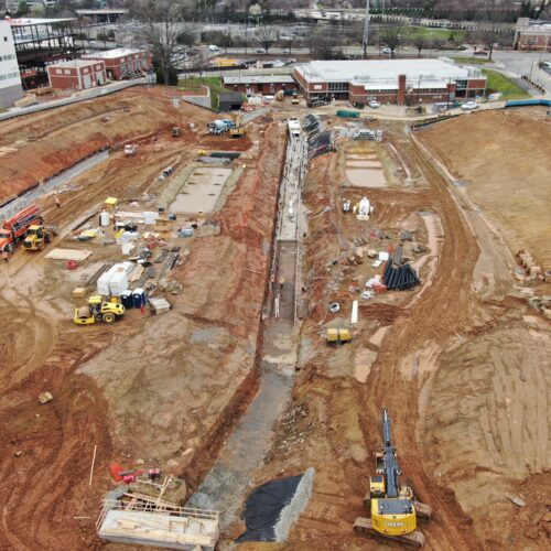 Aerial view of construction site with machinery, vehicles, and workers.