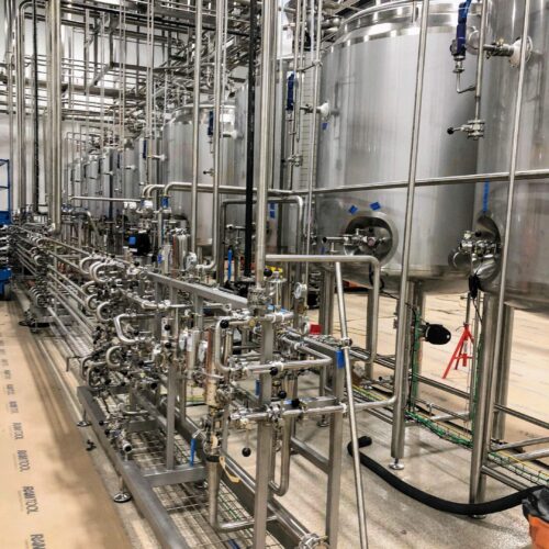 Stainless steel tanks with pipes in an industrial facility