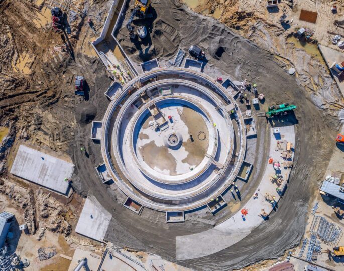 Aerial view of circular building under construction with workers.