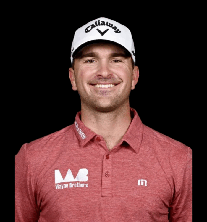 Smiling man in white Callaway cap and red logo shirt.