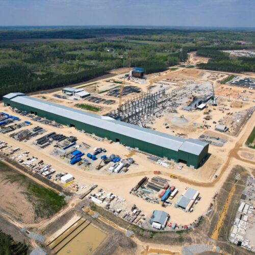 Aerial view of a green warehouse at an industrial site.