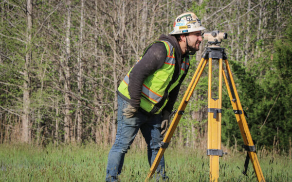 Surveyor looking through camera on tripod