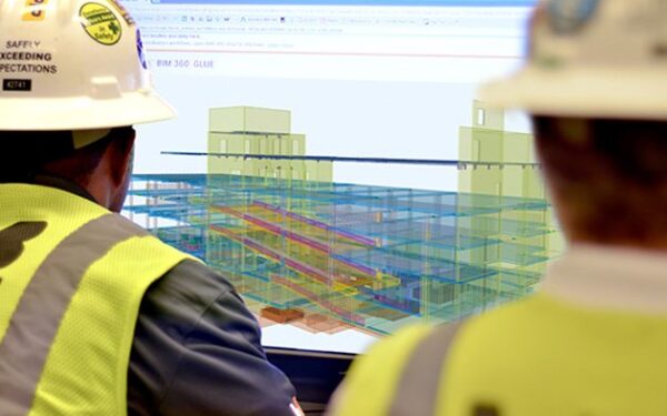 Construction workers staring at a 3D rendering on a screen