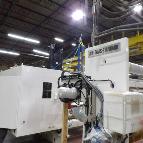 Davis-Standard machine with cables, packaging in factory setting.