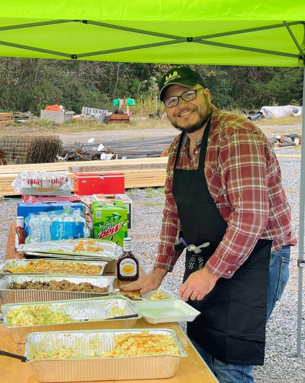 A caterer with an apron smiles