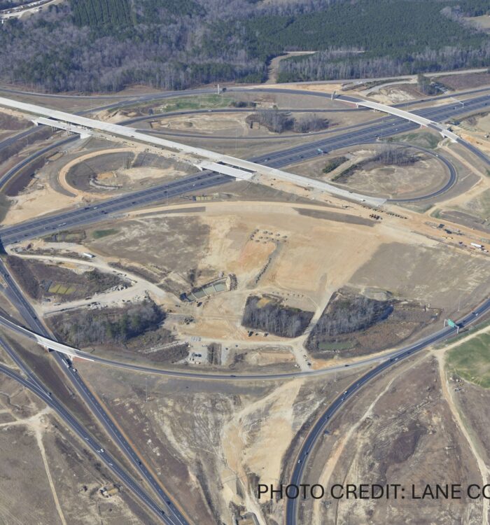 Aerial view of highway interchange construction with roads and ramps.