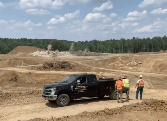 Black pickup truck parked on a dirt construction site