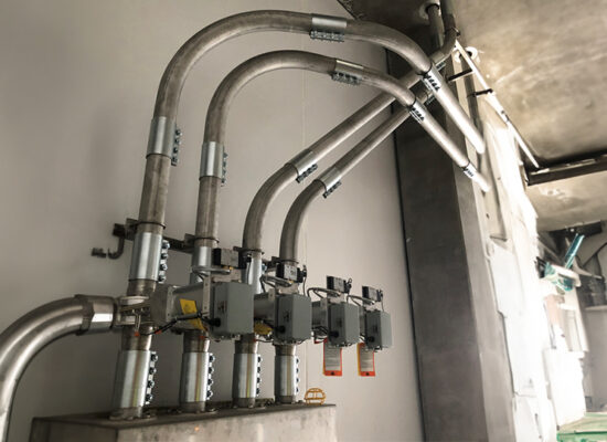 Metal conduits on wall connect to gray junction boxes.