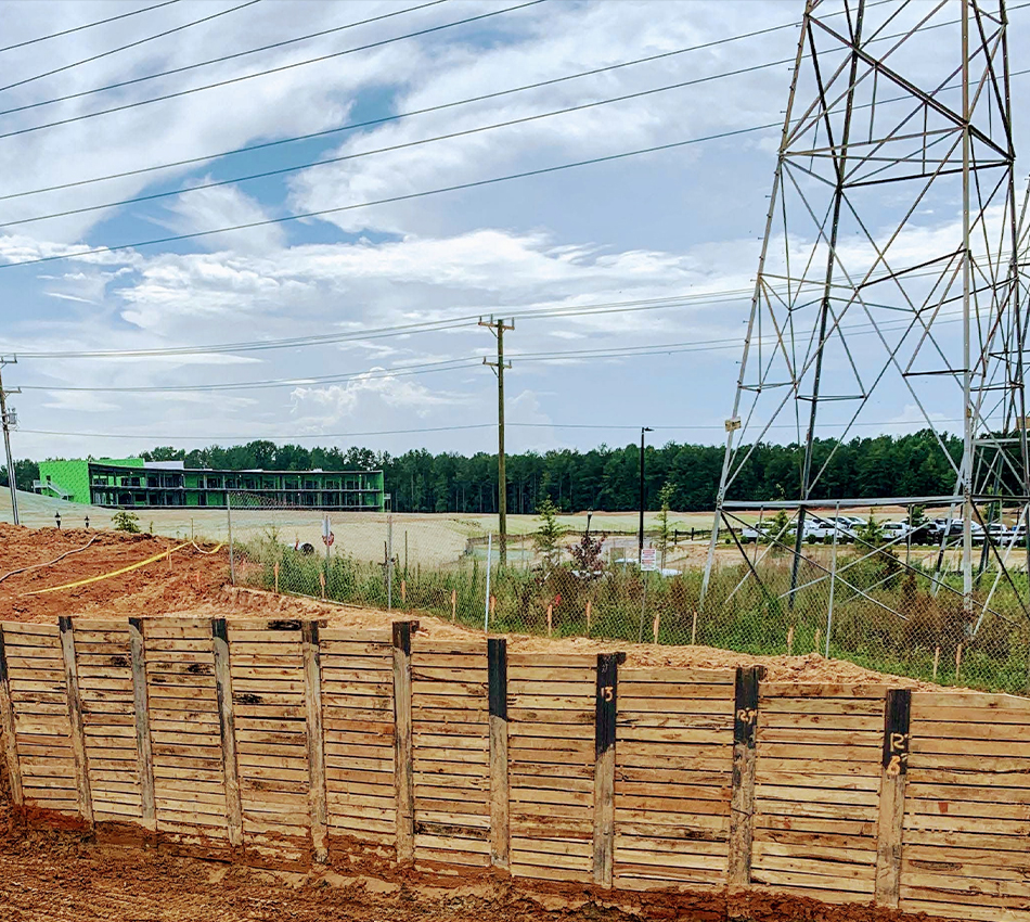 A wooden barrier installed on a dirt construction site