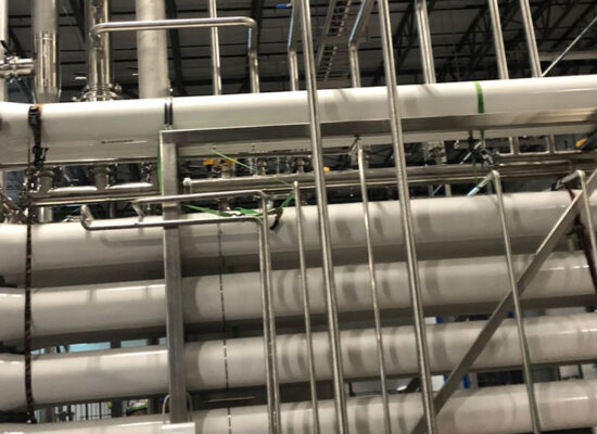 Close-up of industrial water filters and pipes in a factory.