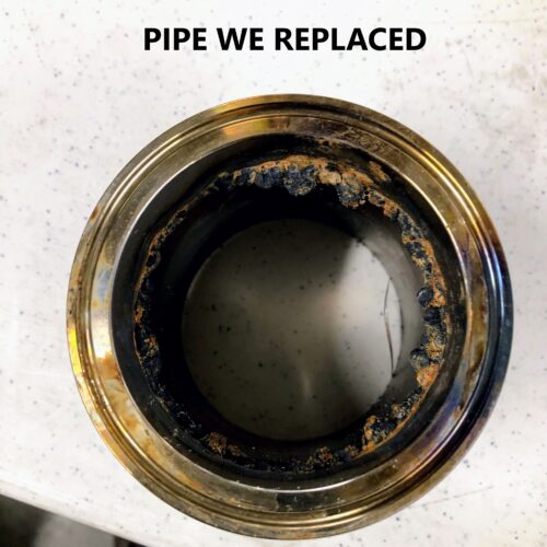 Corroded pipe with buildup on counter; text: “PIPE WE REPLACED.”