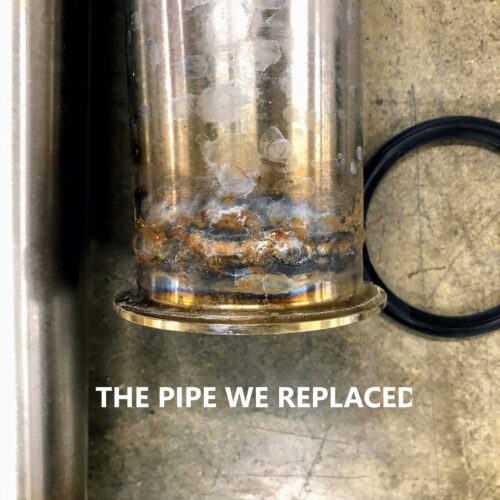 Corroded pipe and black O-ring on concrete; text: THE PIPE WE REPLACED.