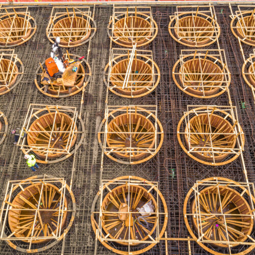 Aerial view: workers with circular wooden molds and steel frames.