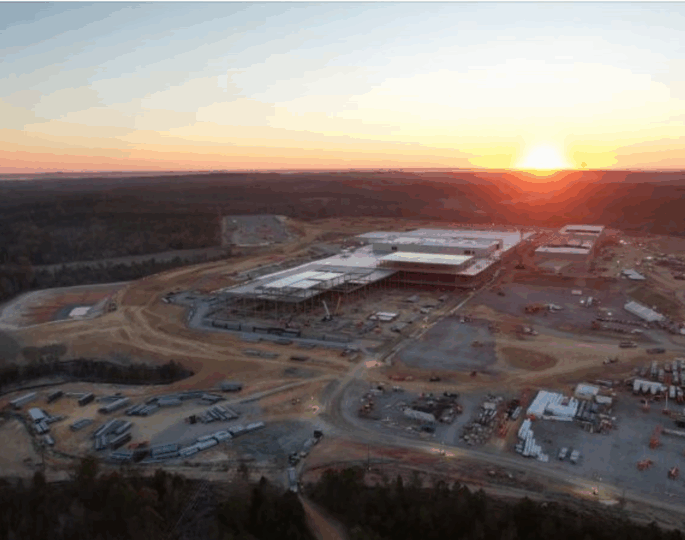 Aerial view of construction site at sunset with unfinished buildings.