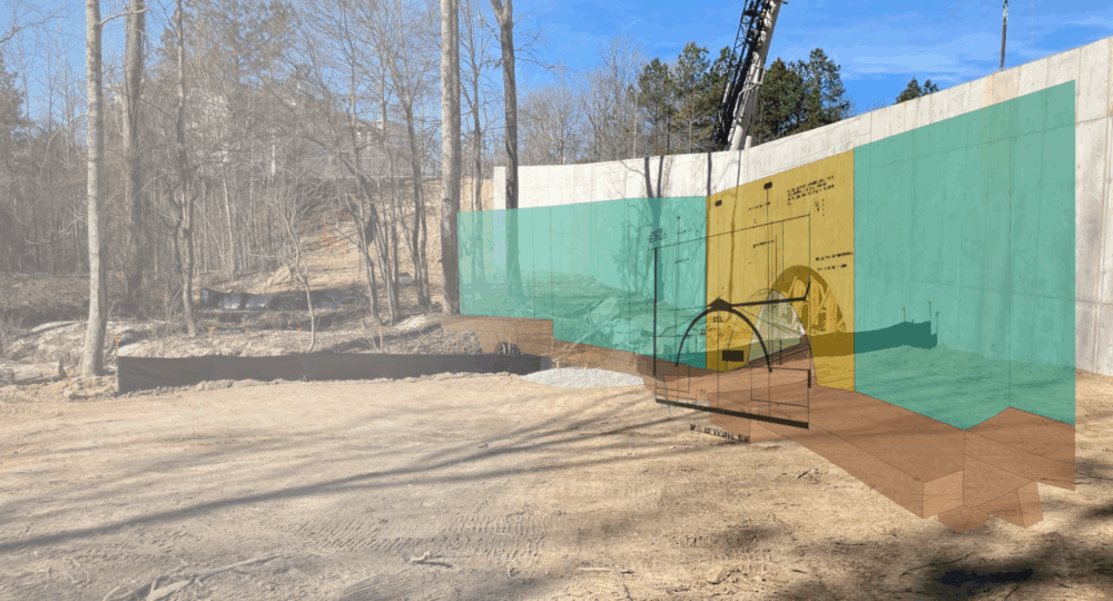 Crane, concrete wall, and digital overlay of planned building layout.